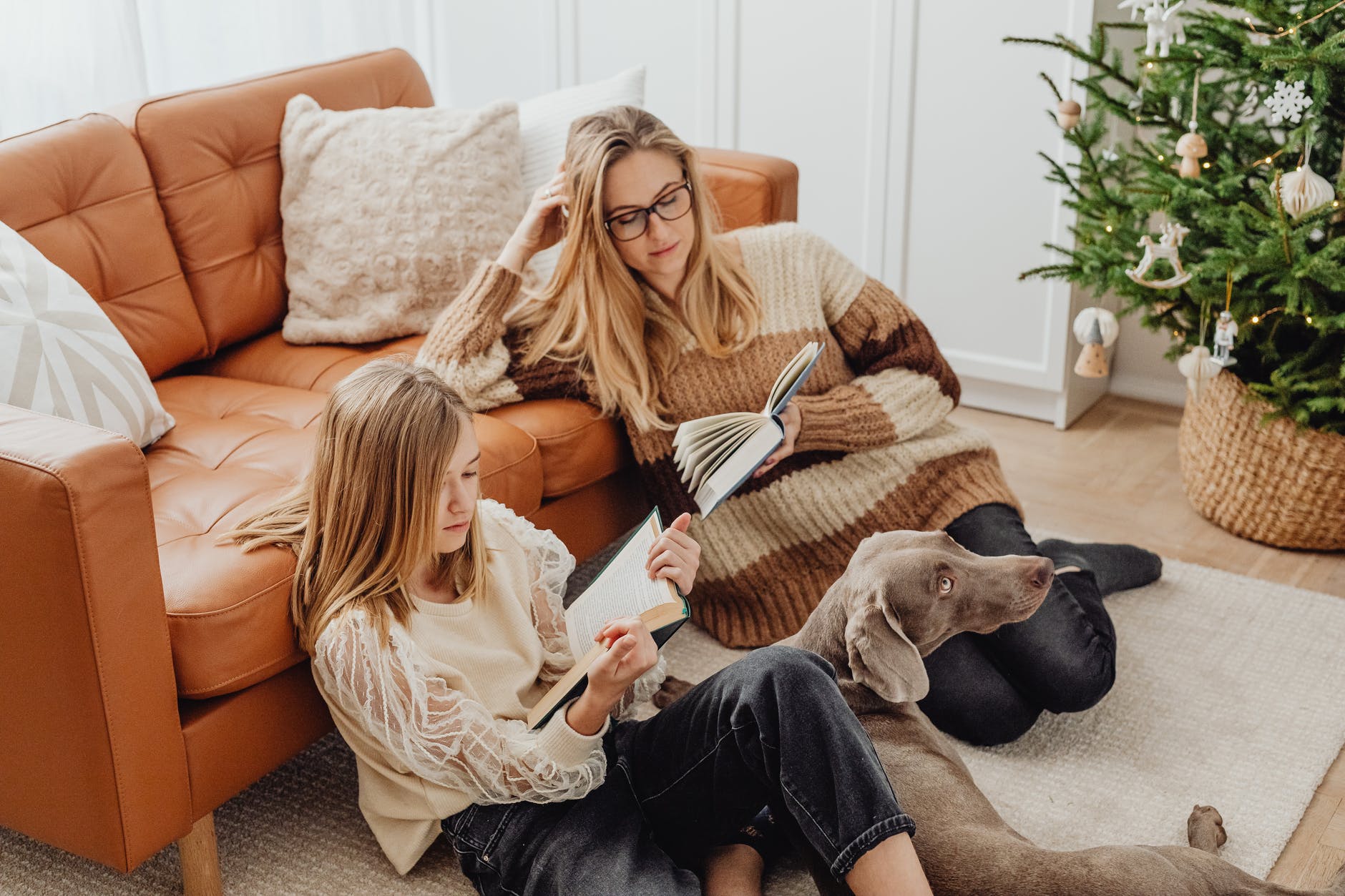 mother and daughter sitting on the floor reading books